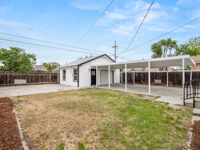 rear view of house with fence, a lawn, and a garage