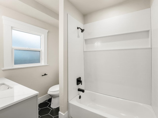 bathroom featuring tile patterned flooring, shower / washtub combination, vanity, baseboards, and toilet
