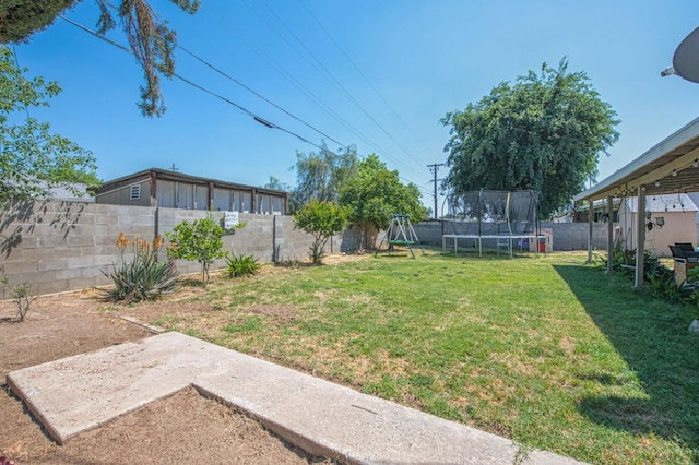 view of yard with a playground, a fenced backyard, and a trampoline