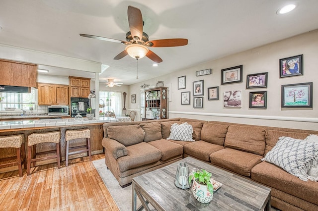 living room featuring a toaster, a ceiling fan, recessed lighting, and light wood-style flooring