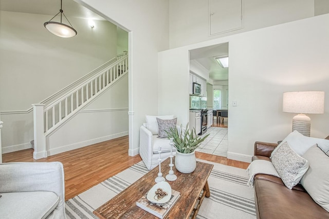2072 E Lexington Ave, Fresno, CA 93720 - living room with wood finished floors, stairs, a high ceiling, baseboards, and attic access