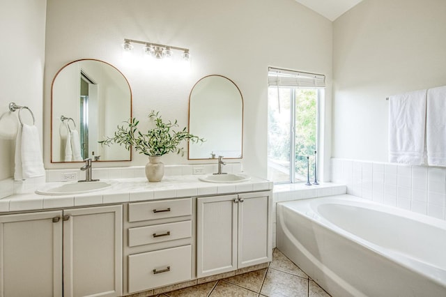 bathroom with double vanity, a sink, a bath, and tile patterned floors