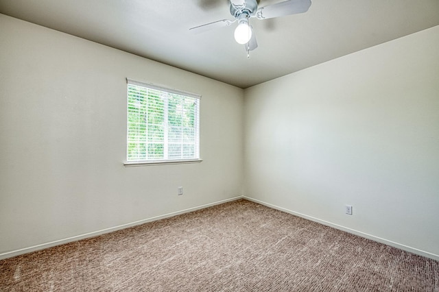 carpeted empty room featuring baseboards and a ceiling fan