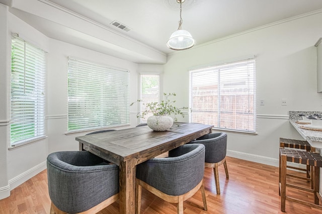 dining space with visible vents, baseboards, crown molding, and light wood-type flooring