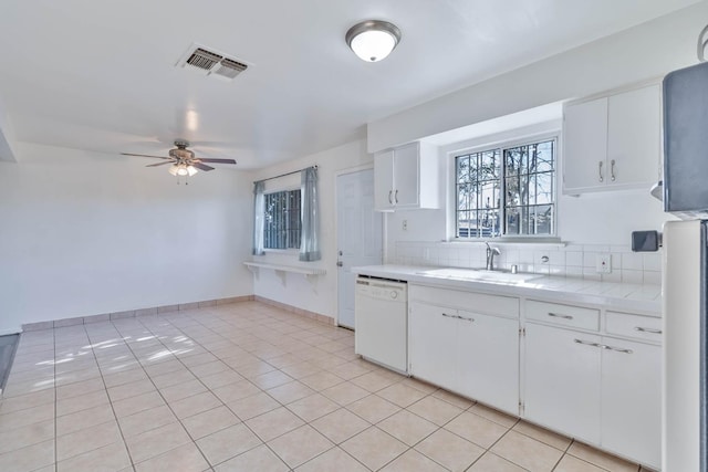 kitchen featuring visible vents, ceiling fan, light countertops, a sink, and dishwasher