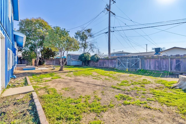 view of yard featuring an outdoor structure, a fenced backyard, and a storage shed