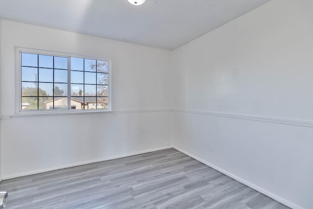 unfurnished room featuring baseboards and wood finished floors