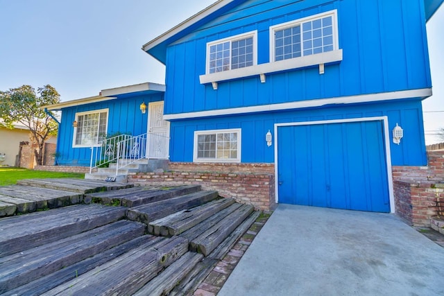 tri-level home featuring a garage and board and batten siding