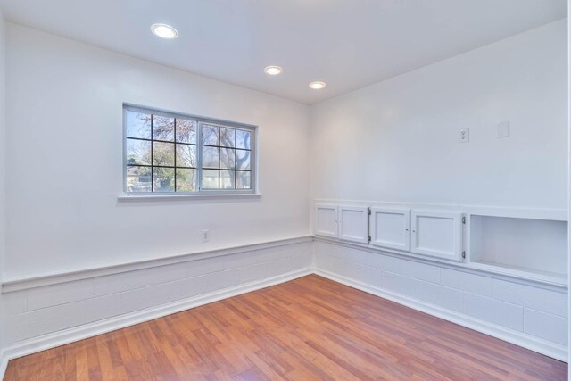 unfurnished room featuring recessed lighting, wainscoting, and wood finished floors