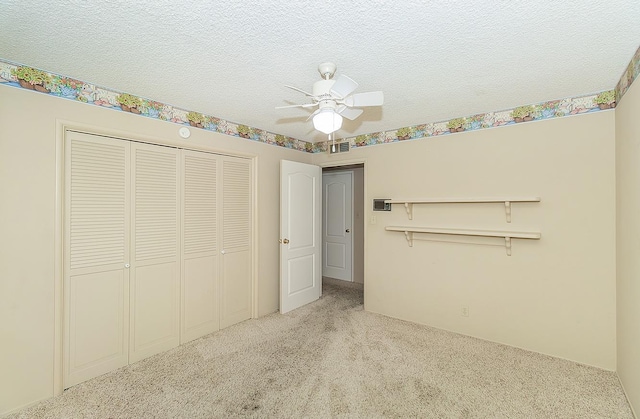 unfurnished bedroom featuring carpet, a closet, a textured ceiling, and visible vents