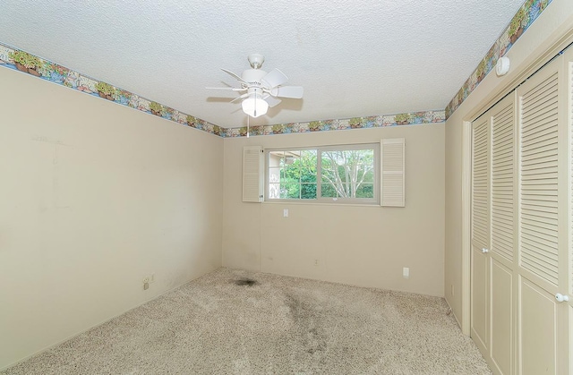 unfurnished bedroom featuring carpet flooring, a textured ceiling, ceiling fan, and a closet