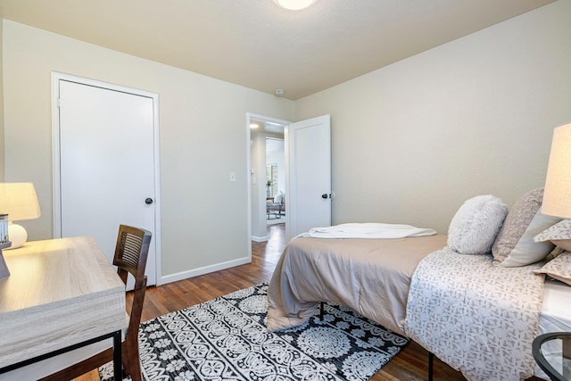 bedroom with baseboards and wood finished floors