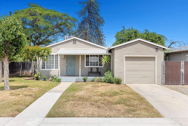 view of front facade featuring fence, an attached garage, stucco siding, a porch, and a front yard
