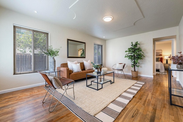 living area with baseboards and hardwood / wood-style floors