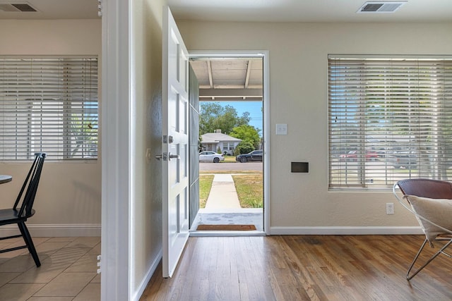 entrance foyer with baseboards, plenty of natural light, and visible vents