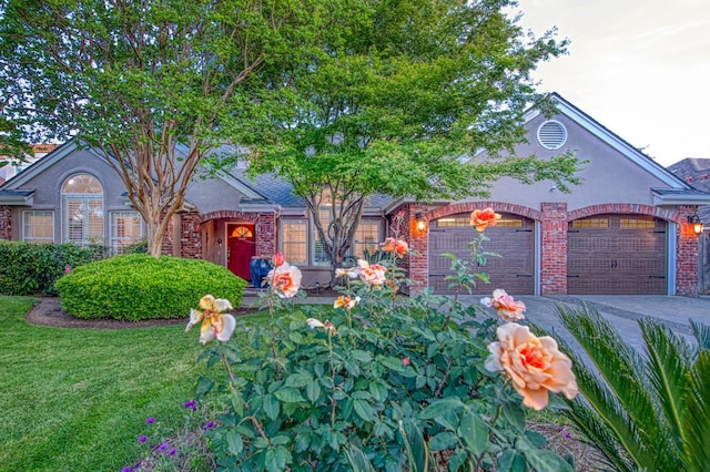 view of front of house with brick siding, an attached garage, driveway, and a front yard