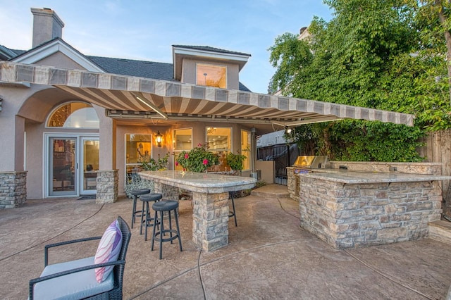 view of patio / terrace with outdoor wet bar, a grill, and exterior kitchen