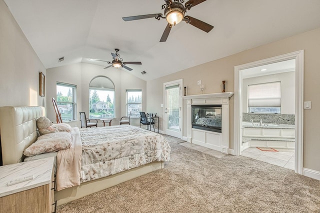 bedroom featuring a ceiling fan, visible vents, vaulted ceiling, connected bathroom, and carpet flooring