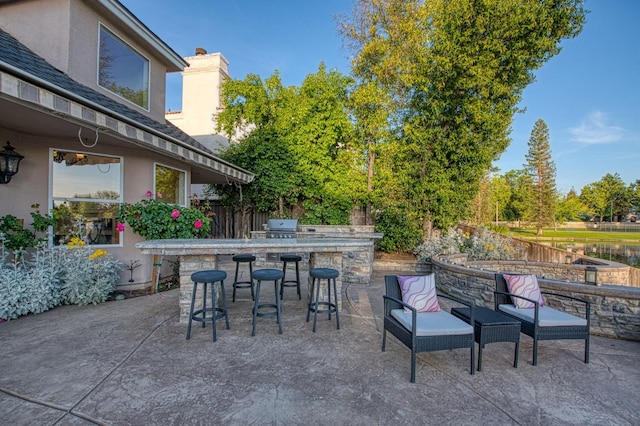 view of patio / terrace featuring an outdoor bar, fence, grilling area, and area for grilling