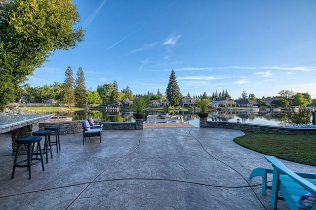 view of patio featuring outdoor dry bar and a water view