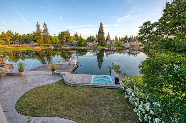 dock area with a water view and an in ground hot tub