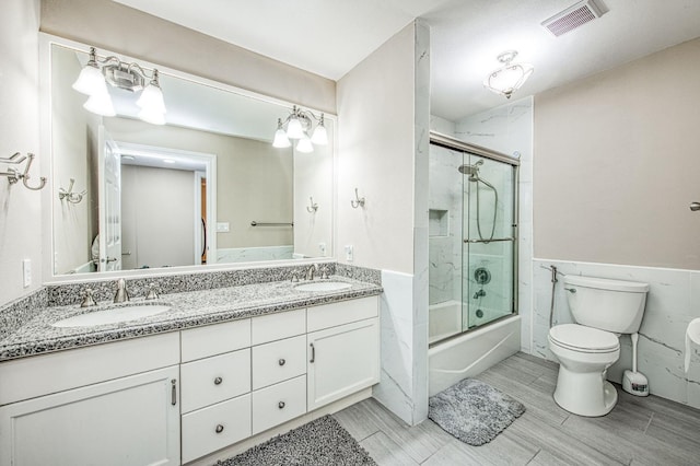bathroom featuring double vanity, toilet, visible vents, and a sink