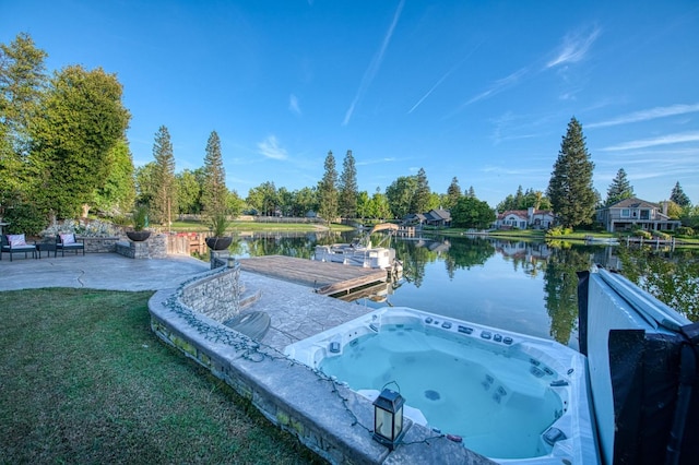 exterior space featuring an outdoor hot tub and a water view