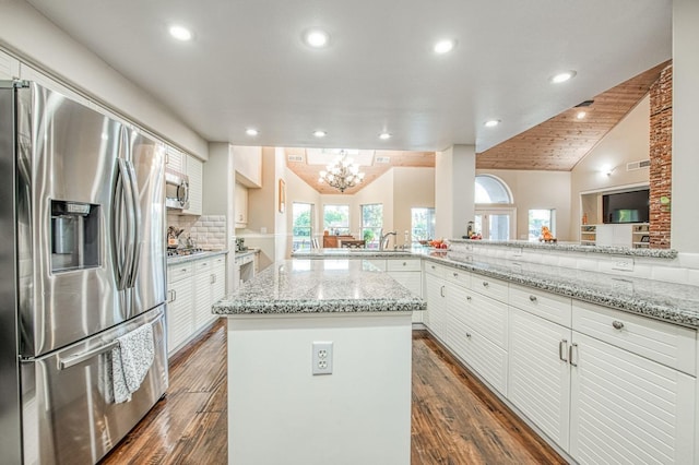 kitchen with an inviting chandelier, recessed lighting, a center island, white cabinets, and stainless steel appliances