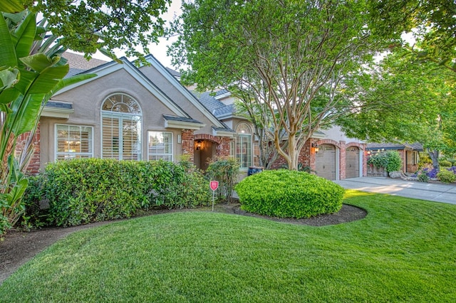 view of front of house with a garage, driveway, a front yard, and stucco siding
