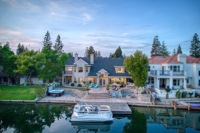 rear view of property featuring a patio, a chimney, and a balcony