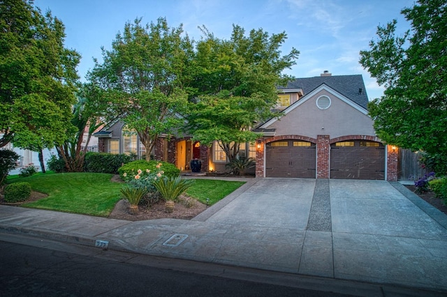 view of front facade featuring driveway, a front yard, and a garage