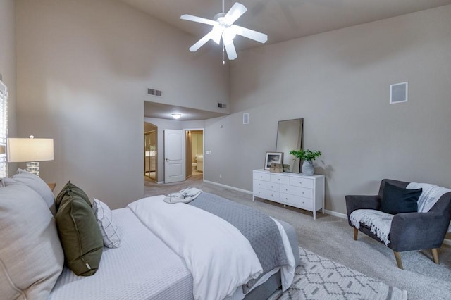 bedroom with high vaulted ceiling, baseboards, light colored carpet, and visible vents