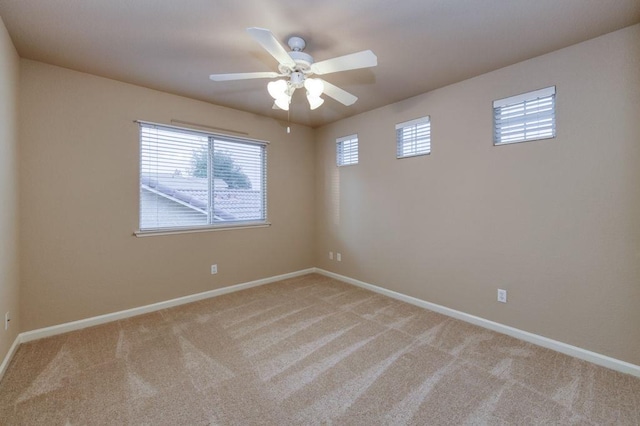 spare room with baseboards and light carpet