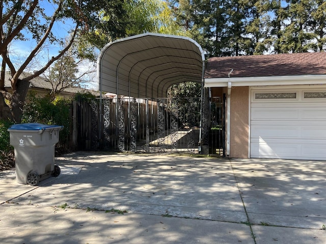 view of car parking with fence, a garage, driveway, and a carport