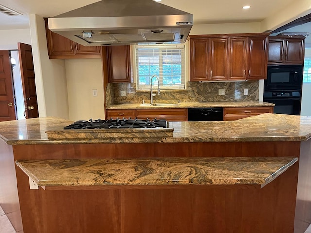 kitchen featuring exhaust hood, visible vents, a center island, a sink, and black appliances