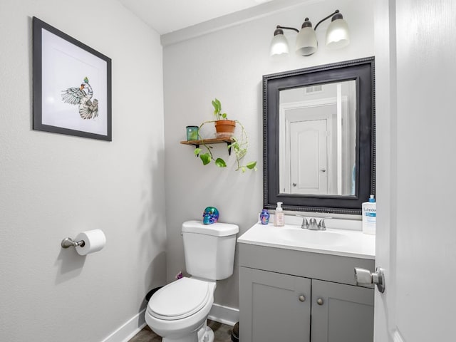 bathroom featuring baseboards, toilet, and vanity