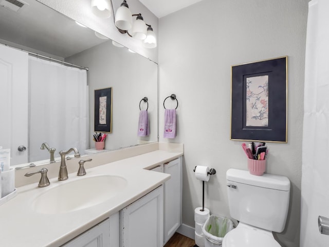 bathroom featuring visible vents, toilet, and vanity