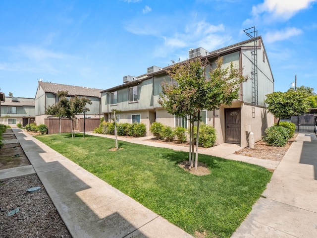 view of home's community with fence, a lawn, and a residential view