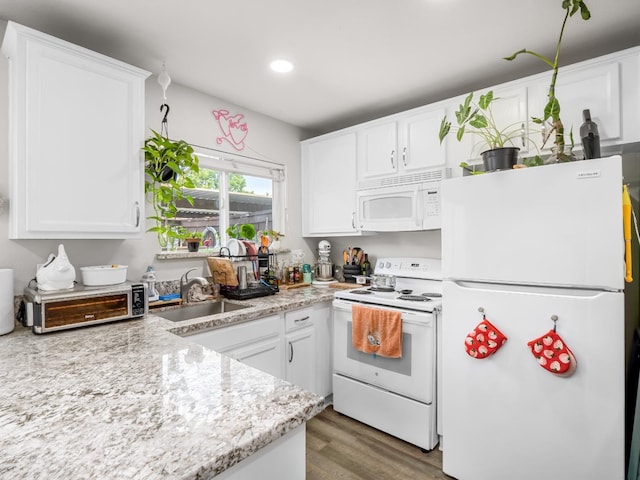 kitchen with white appliances, white cabinets, and a sink