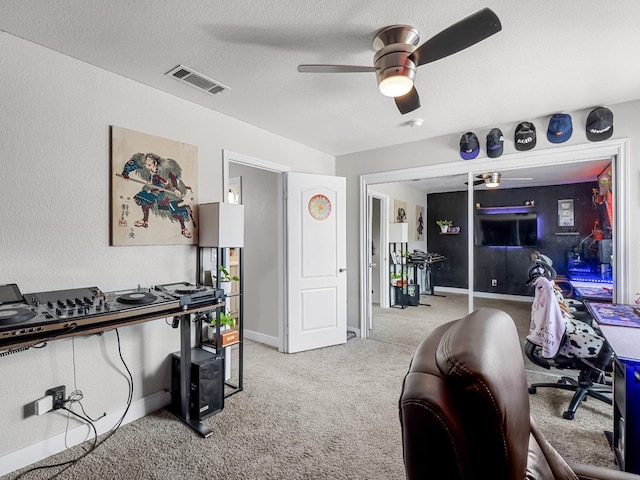 office with visible vents, light carpet, baseboards, ceiling fan, and a textured ceiling