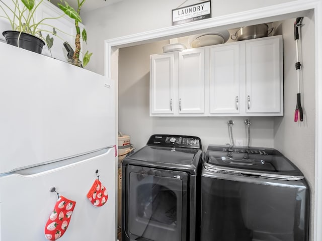 laundry room with washing machine and clothes dryer and cabinet space