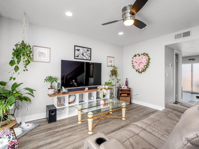 living area featuring visible vents, baseboards, ceiling fan, and wood finished floors