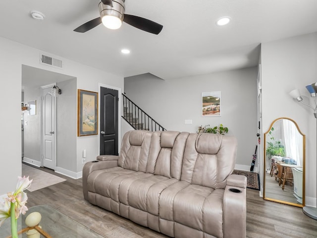 living room featuring baseboards, a ceiling fan, wood finished floors, and visible vents