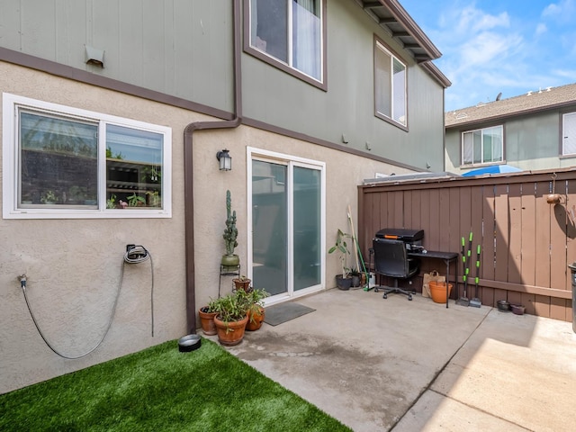 back of house with stucco siding, a patio area, and fence
