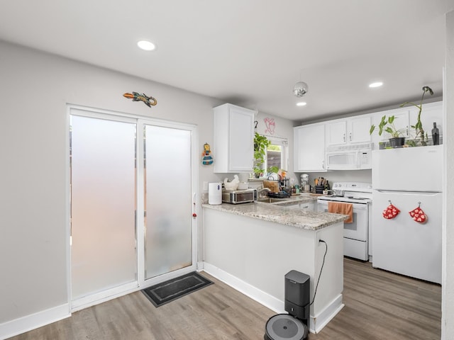 kitchen featuring white appliances, a peninsula, white cabinetry, and light wood-type flooring
