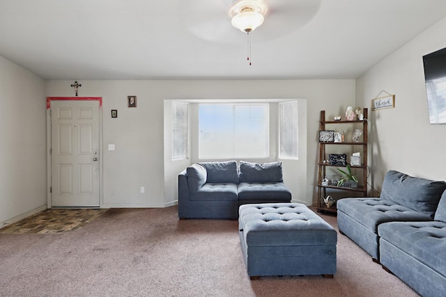 carpeted living area with baseboards and ceiling fan