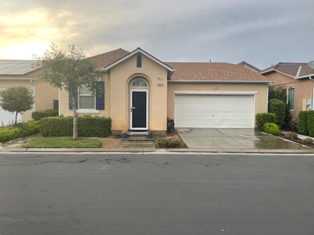 single story home featuring a garage, stucco siding, driveway, and roof with shingles