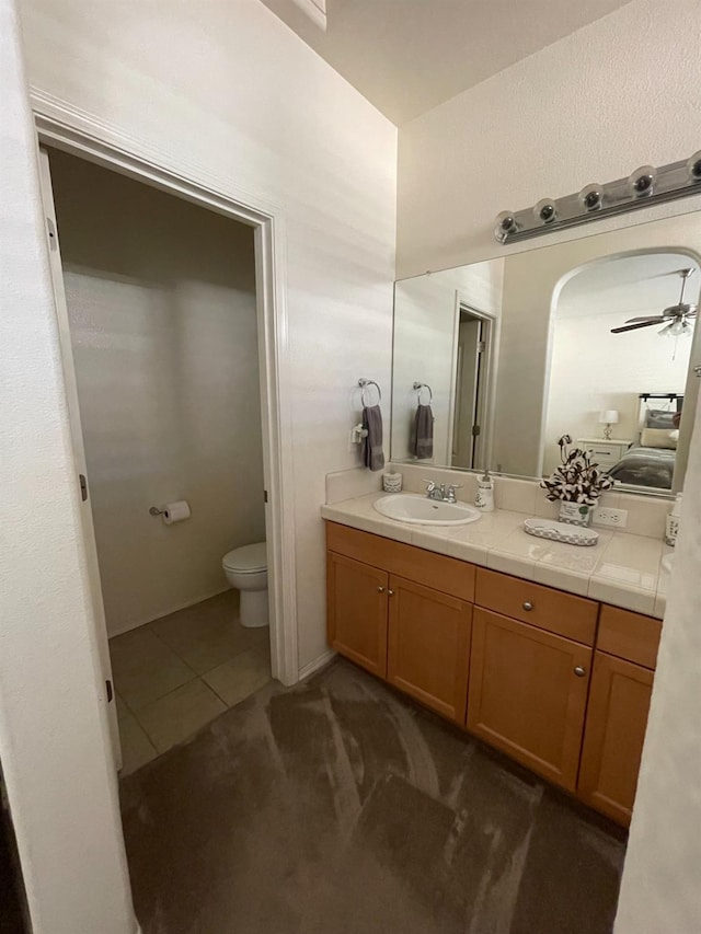 bathroom with vanity, a ceiling fan, tile patterned floors, and toilet