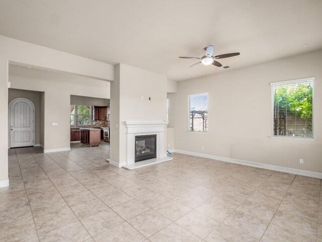 7993 N Justin Ave, Fresno, CA 93720 - unfurnished living room featuring light tile patterned floors, visible vents, a ceiling fan, and a wealth of natural light
