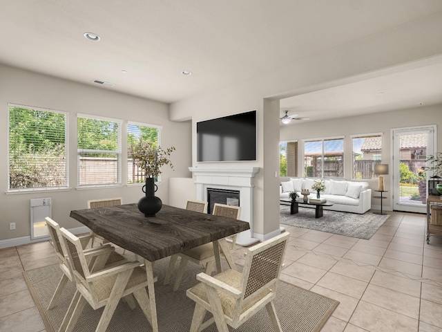 7993 N Justin Ave, Fresno, CA 93720 - dining room with light tile patterned floors, visible vents, a glass covered fireplace, and a healthy amount of sunlight